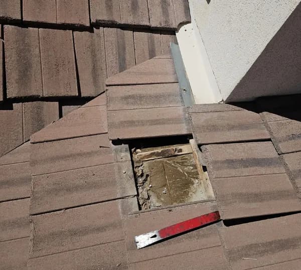 Cracked and missing concrete roof tiles exposing the underlayment